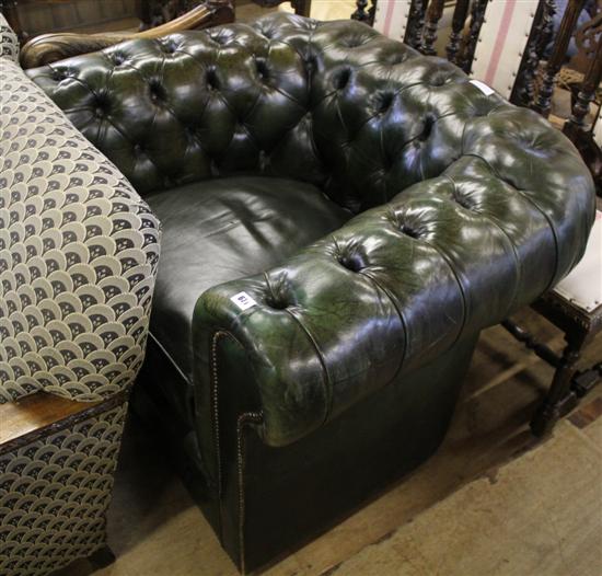 Green buttoned leather club chair